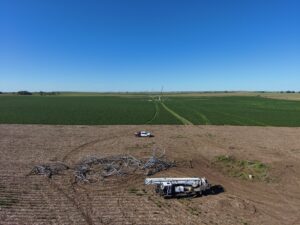 Power transmission towers lie on their sides in an open field